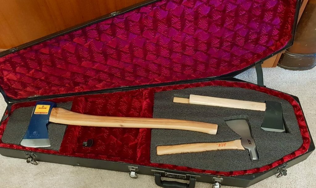 Adam Buckley's coffin-shaped guitar case containing hatchets and a full size axe spaced apart by foam cutouts